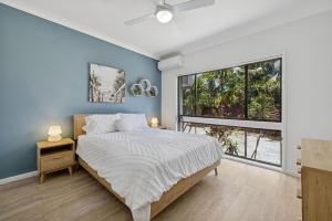 a bedroom with a bed and a large window at Galoola Hidden Gem - 2,97 Galoola Drive, Rooftop outdoor area with spectacular views, Wi-Fi and air conditioning. in Nelson Bay