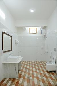 Un baño blanco con dos lavabos y un espejo. en GOVIND GARH NATHDWARa, en Nathdwara