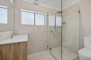 a bathroom with a shower and a sink and a toilet at Galoola Hidden Gem - 2,97 Galoola Drive, Rooftop outdoor area with spectacular views, Wi-Fi and air conditioning. in Nelson Bay +18 photos