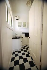 uma casa de banho com piso em xadrez preto e branco em Regan House em Stratford