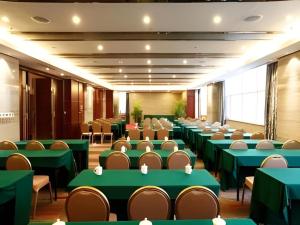 a conference room with green tables and chairs at The Prosperous City Hotel Weifang in Changle