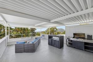 a large living room with a kitchen and a grill at Galoola Hidden Gem - 2,97 Galoola Drive, Rooftop outdoor area with spectacular views, Wi-Fi and air conditioning. in Nelson Bay