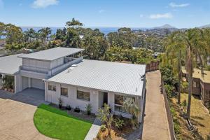 an aerial view of a white house with palm trees at Galoola Hidden Gem - 2,97 Galoola Drive, Rooftop outdoor area with spectacular views, Wi-Fi and air conditioning. in Nelson Bay