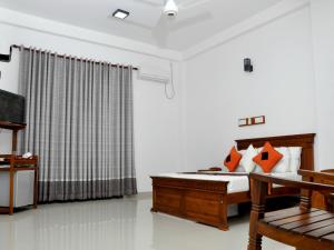 a bedroom with a bed and a table and a television at Villa 234 in Galle