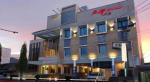 PadangsidimpuanMega Permata Hotel的一座前面摆放着椅子的大楼