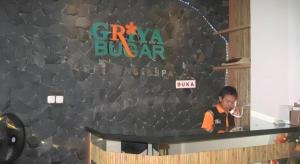 a man standing in front of a bar in a restaurant at Griya Jogja Hotel in Yogyakarta