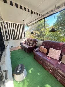 ein Wohnzimmer mit 2 Ledersofas und einem Tisch in der Unterkunft Cocoa Home Women Only Rooms Chapalita in Guadalajara