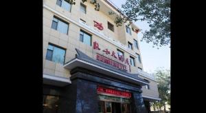 a building with a sign on the front of it at Dunhuang Dunhe Hotel in Dunhuang