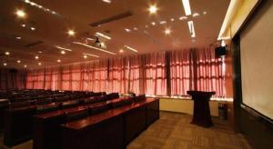 a large lecture hall with chairs and a podium at Xian Song Of Apple Hot Spring Hotel in Xi'an