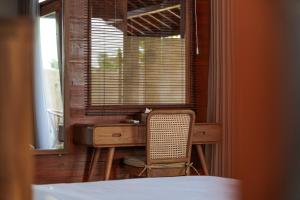 a desk with a chair in a room with a window at Pondok Raka Ubud in Ubud