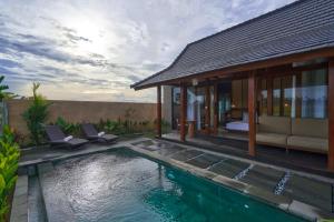 a villa with a swimming pool next to a house at Pondok Raka Ubud in Ubud