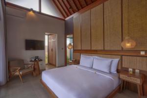 a bedroom with a large white bed in a room at Pondok Raka Ubud in Ubud