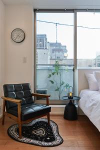 a bedroom with a chair and a bed and a window at Mint House Ebisu - 3 Story, Artsy & Modern Home in Shibuya in Tokyo