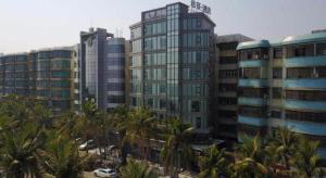 湛江Xana Lite Zhanjiang Guanhai Corridor的前面有棕榈树的高楼