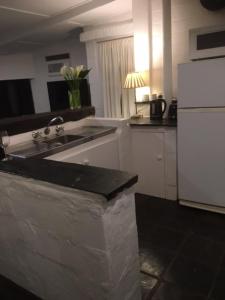a kitchen with a sink and a white refrigerator at Peppertree Cottage in a beautiful Rural Setting in Mintaro +7 photos