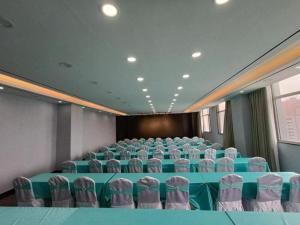 uma sala de conferências com uma mesa azul e cadeiras em Xana Hotelle Jinan Daminghu North Gate em Jinan