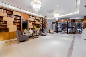 a lobby with chairs and tables and bookshelves at Yitel Shanghai Hongqiao Railway Station National Convention and Exhibition Center in Fangjiayao