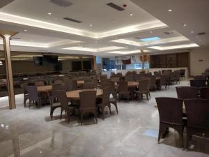 哈尔滨Lavande Hotels Harbin Railway Station Zhanqian Square的宴会厅配有桌椅和电视