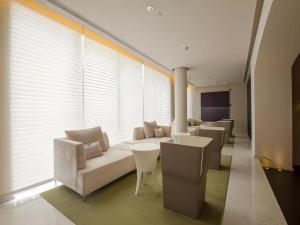a living room with white couches and tables and windows at Jinjiang Metropolo Classiq Shanghai Jing'an Temple in Shanghai