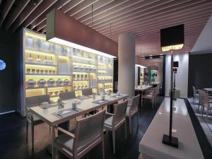 a restaurant with tables and chairs and a wall of dishes at Jinjiang Metropolo Classiq Shanghai Jing'an Temple in Shanghai