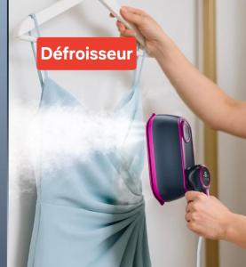 a woman is blow drying a dress with a blow dryer at Studio indépendant L'an nexe in Saint-Méloir-des-Ondes