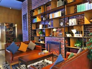 a living room with a couch and a fireplace at James Joyce Coffetel Guangyuan High-Speed Railway Station Dongba Municipal Government in Guangyuan
