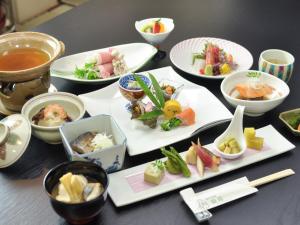 a table with plates of food and bowls of food at Senso Yutagawa in Tsuruoka