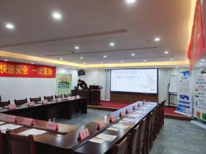 uma sala de conferências com mesas e cadeiras e uma apresentação em James Joyce Coffetel Zhengzhou CBD Exhibition Center Provincial People's Hospital em Zhengzhou