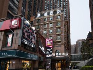 uma rua movimentada da cidade com prédios altos e lojas em James Joyce Coffetel Zhengzhou CBD Exhibition Center Provincial People's Hospital em Zhengzhou