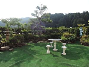 a table and two stools in a garden at Senso Yutagawa in Tsuruoka