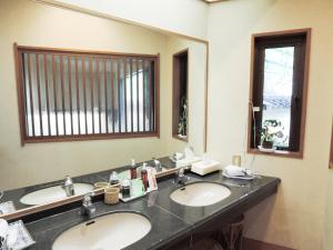 a bathroom with two sinks and a large mirror at Senso Yutagawa in Tsuruoka +17 photos