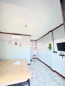 Un dormitorio con una cama y un televisor de pantalla plana. en เกาะลิบงKohlibong forest house, en Trang