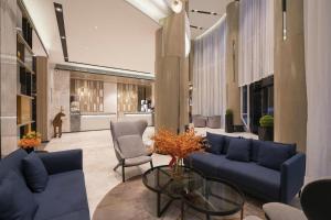 ein Wohnzimmer mit blauen Sofas und einem Glastisch in der Unterkunft Echarm Hotel Jianshui Gucheng in Jianshui