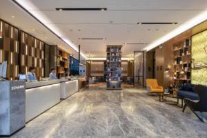 a lobby of a hotel with people sitting at a counter at Echarm Hotel Nanning Chaoyang Square River View in Nanning