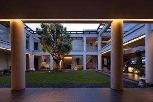 a large white building with a tree in the courtyard at ANALO Resort Hotel in Lijiang