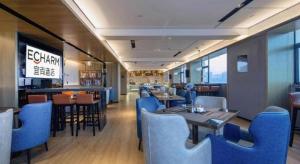 a restaurant with blue chairs and tables in a room at Echarm Hotel Nanning Chaoyang Square River View in Nanning