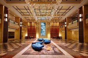 a lobby with blue couches and a chandelier at Shinagawa Prince Hotel in Tokyo