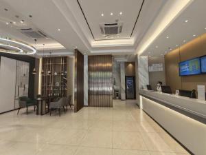 a lobby of a hotel with a woman sitting at a desk at City Comfort Inn Yulin Jincheng Center Municipal Government in Yulin