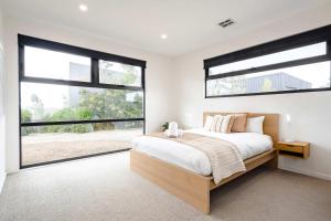 a bedroom with a large bed and large windows at Ocean Vista Escape Jan Juc in Bellbrae +33 photos