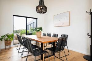 a dining room with a wooden table and chairs at Ocean Vista Escape Jan Juc in Bellbrae