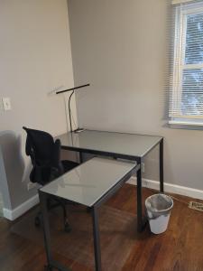 a glass desk with a chair and a lamp at Townhome Near Northwestern and Hospital in Evanston