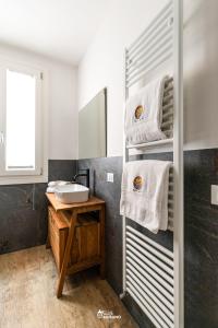 a bathroom with a sink and towels on a shelf at MISTRO House by Sleep in MURANO in Murano