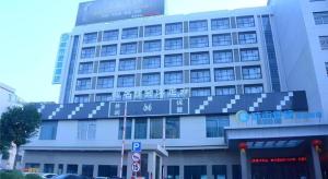 a large building with a sign on the side of it at City Comfort Inn Dongguan Dalang Yuanda City Plaza in Dongguan
