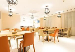 una sala da pranzo con tavoli, sedie e luci di City Comfort Inn Nanning Guangxi University for Nationalities a Nanning