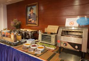 una mesa con un buffet de comida y un microondas en Nak Nakara Hotel-SHA Extra Plus, en Chiang Rai