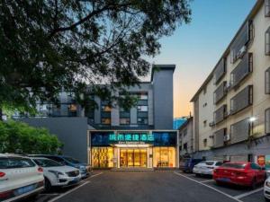 ein Parkplatz mit vor einem Gebäude geparkten Autos in der Unterkunft City Comfort Inn Nanning Nanhu Park Art College in Nanning