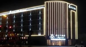 un grande edificio illuminato di notte di Magnotel Nanjing Lishui Baota Bei Road a Lishui