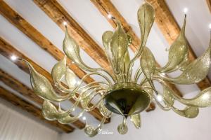 a brass chandelier hanging from a ceiling at MISTRO House by Sleep in MURANO in Murano +20 photos