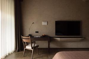 a bedroom with a desk with a television and a chair at ANALO Resort Hotel in Lijiang