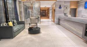 a lobby with a couch and a chair in a building at City Comfort Inn Zhaoqing Sihui Nanjiang Industrial Park in Xiahuangtang